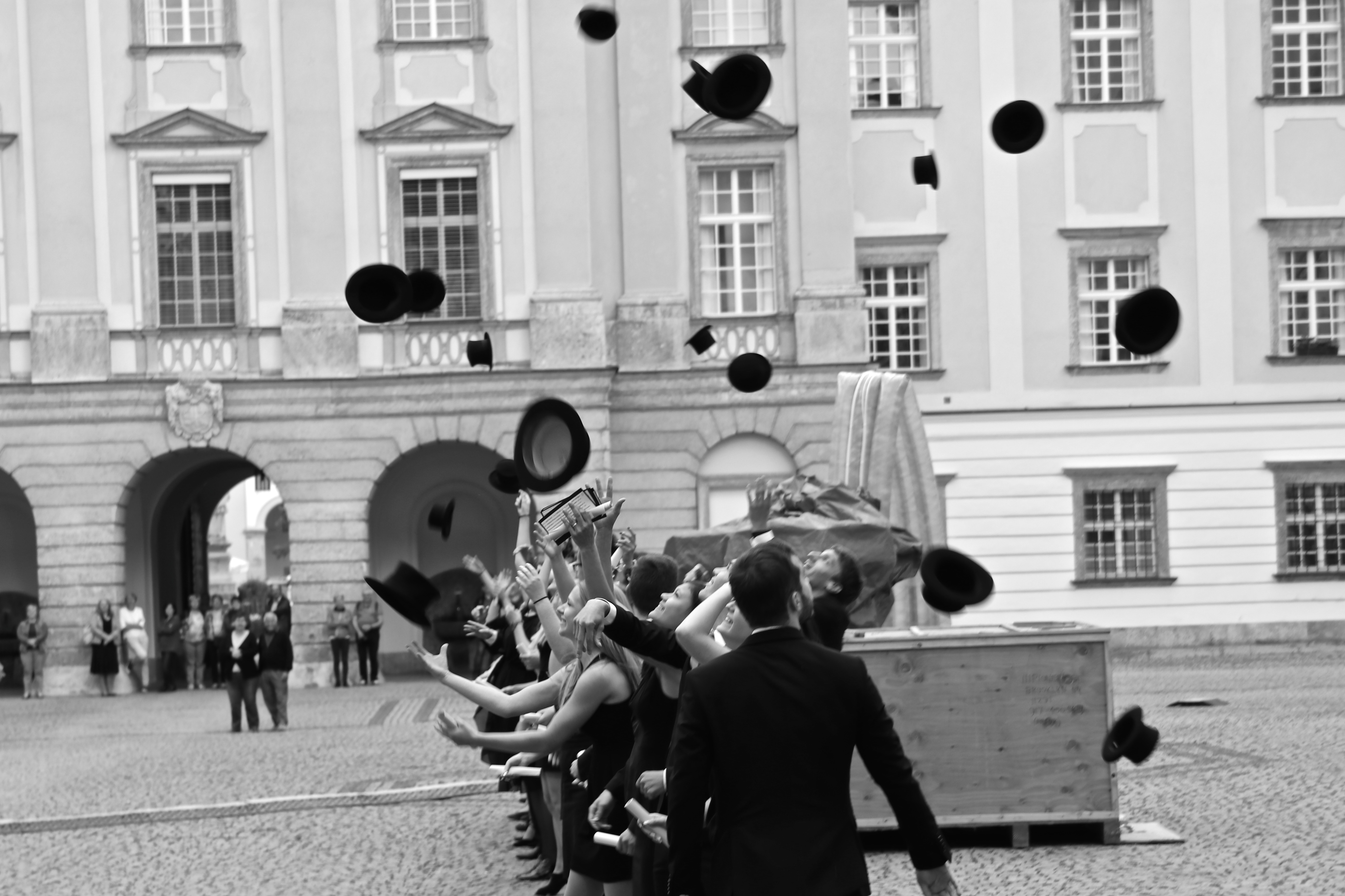 Maturanten werfen freudvoll deren Hüte in die Luft