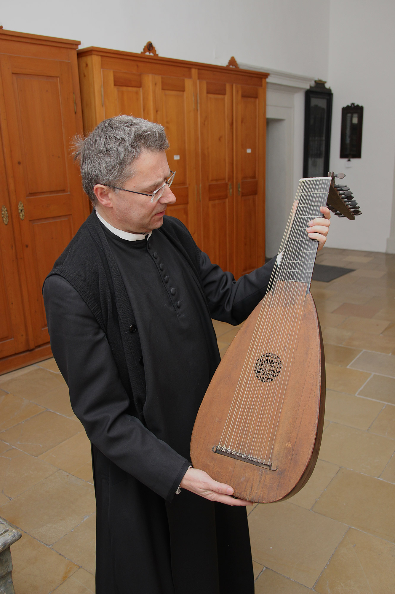 Mönch zeigt eine der ältesten Lauten der Welt aus dem Stift Kremsmünster