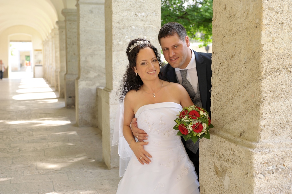 Junges Brautpaar posiert an einer Steinsäule im Stift Kremsmünster