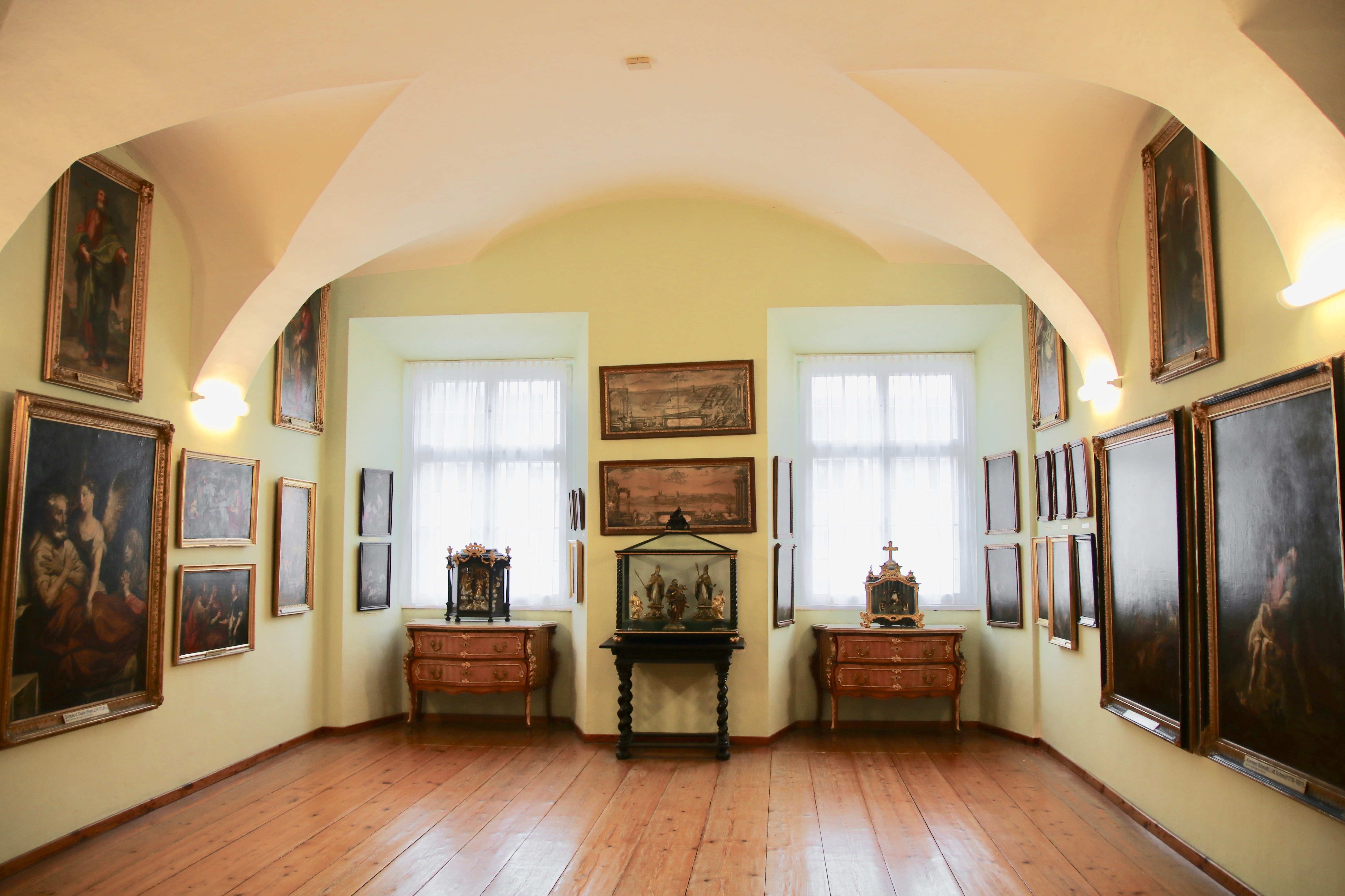 Heller, freundlicher Raum mit Gewölbe und Gemälden an den Wänden