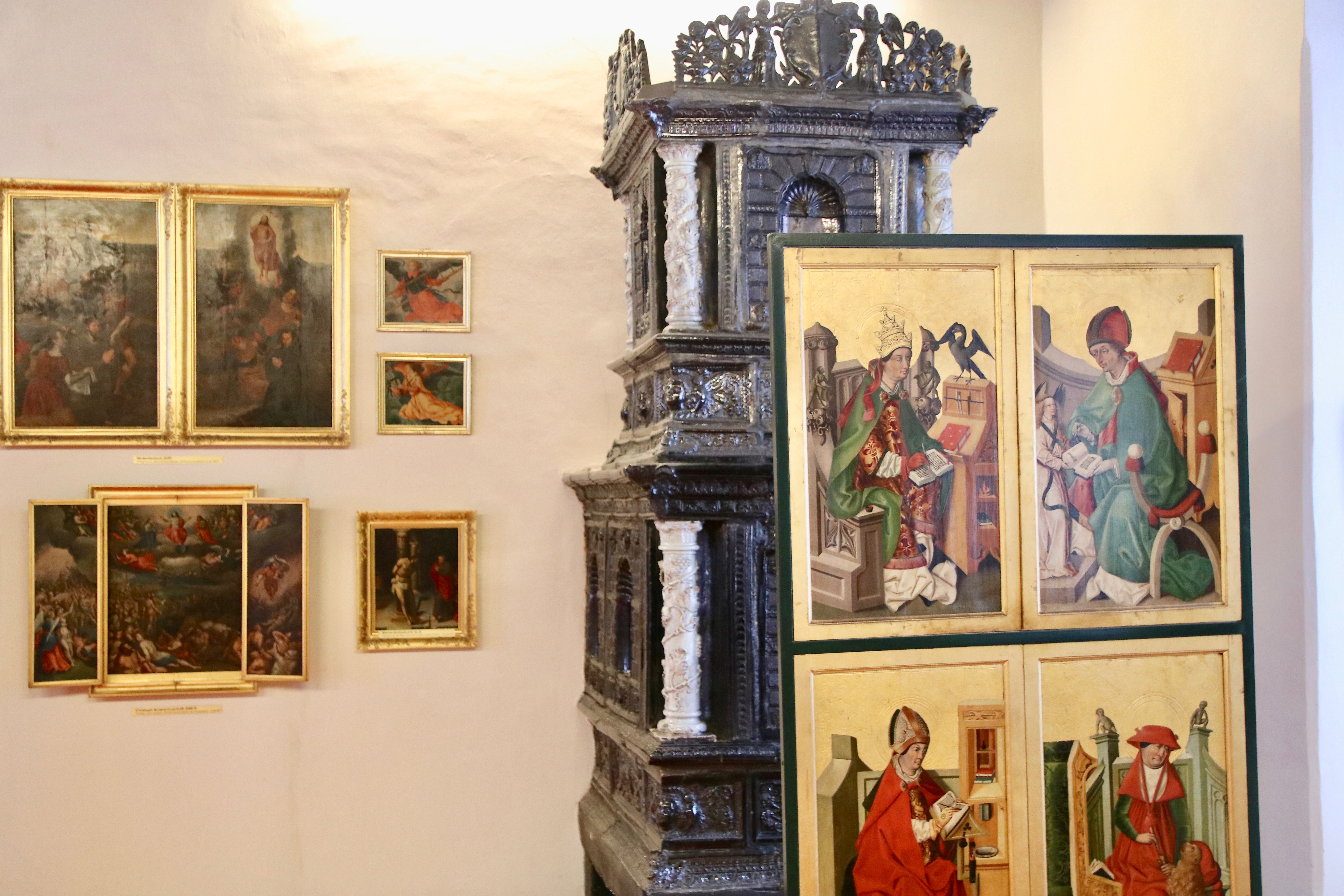 Kunstvolle Portraits und ein gut erhaltener, dunkelgrauer Kachelofen