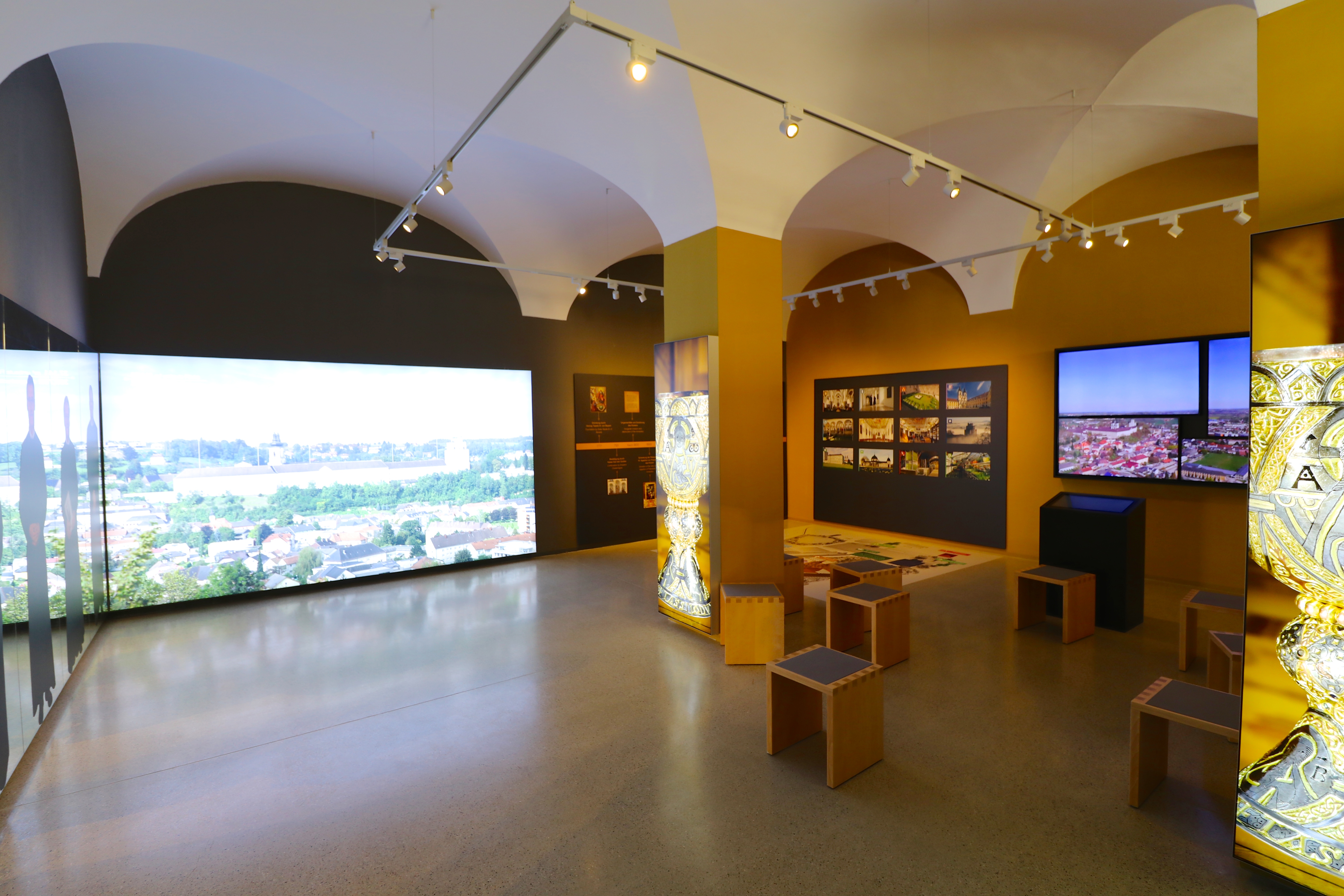 Modernes Museum mit Bildschirmen und Hocker