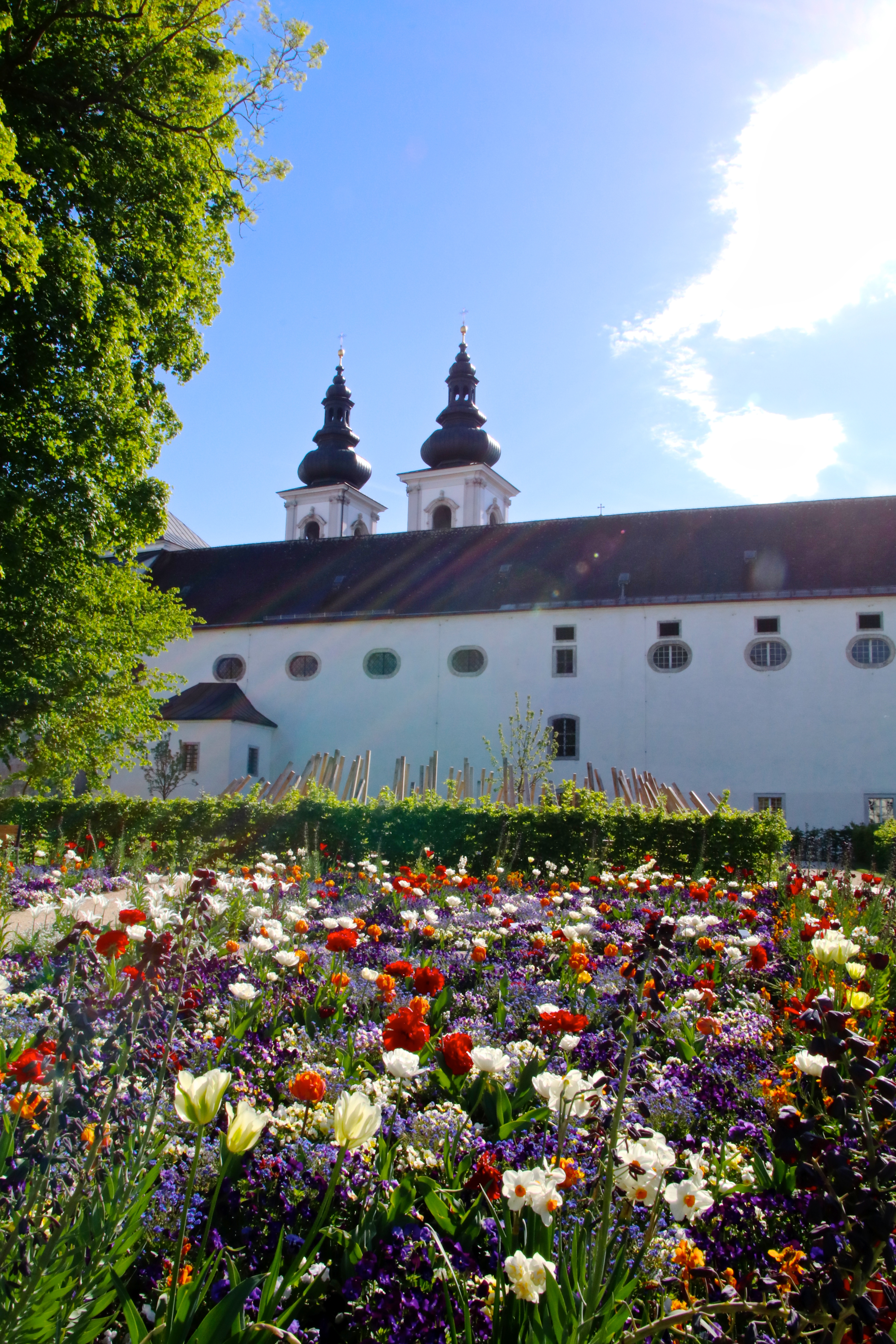 Blick aus dem bunten Blumenbeet auf die Stiftsmauern und Stiftstürme