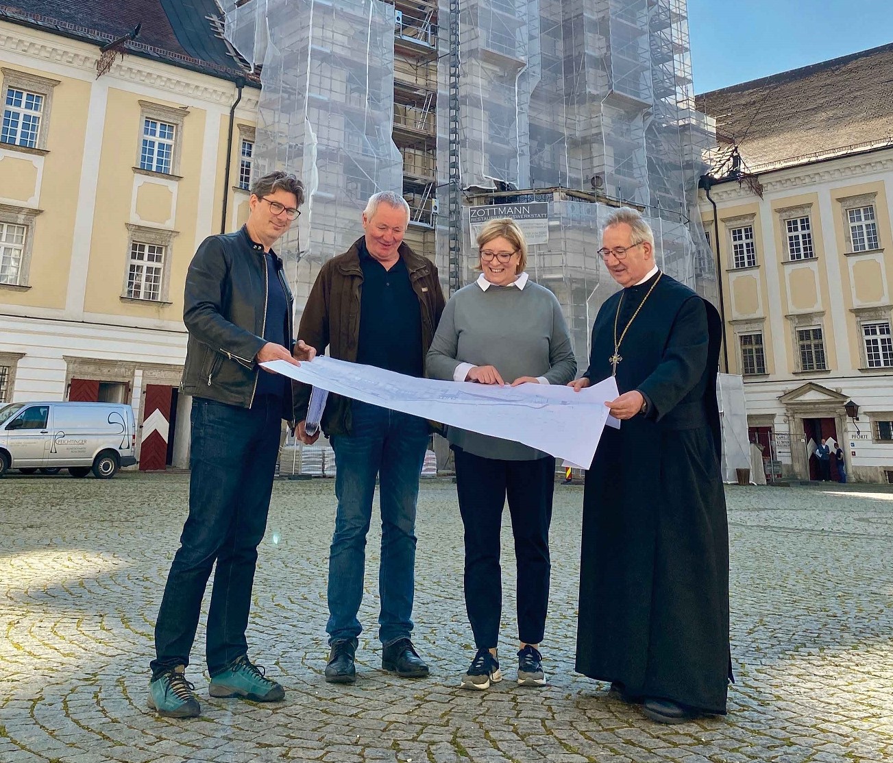 Baubesprechung mit Plan vor der Stiftskirche, Abt Ambros Ebhart und Dipl. Ing. Richard Hackl sowie zwei externe Mitarbeiter der Projektplanung