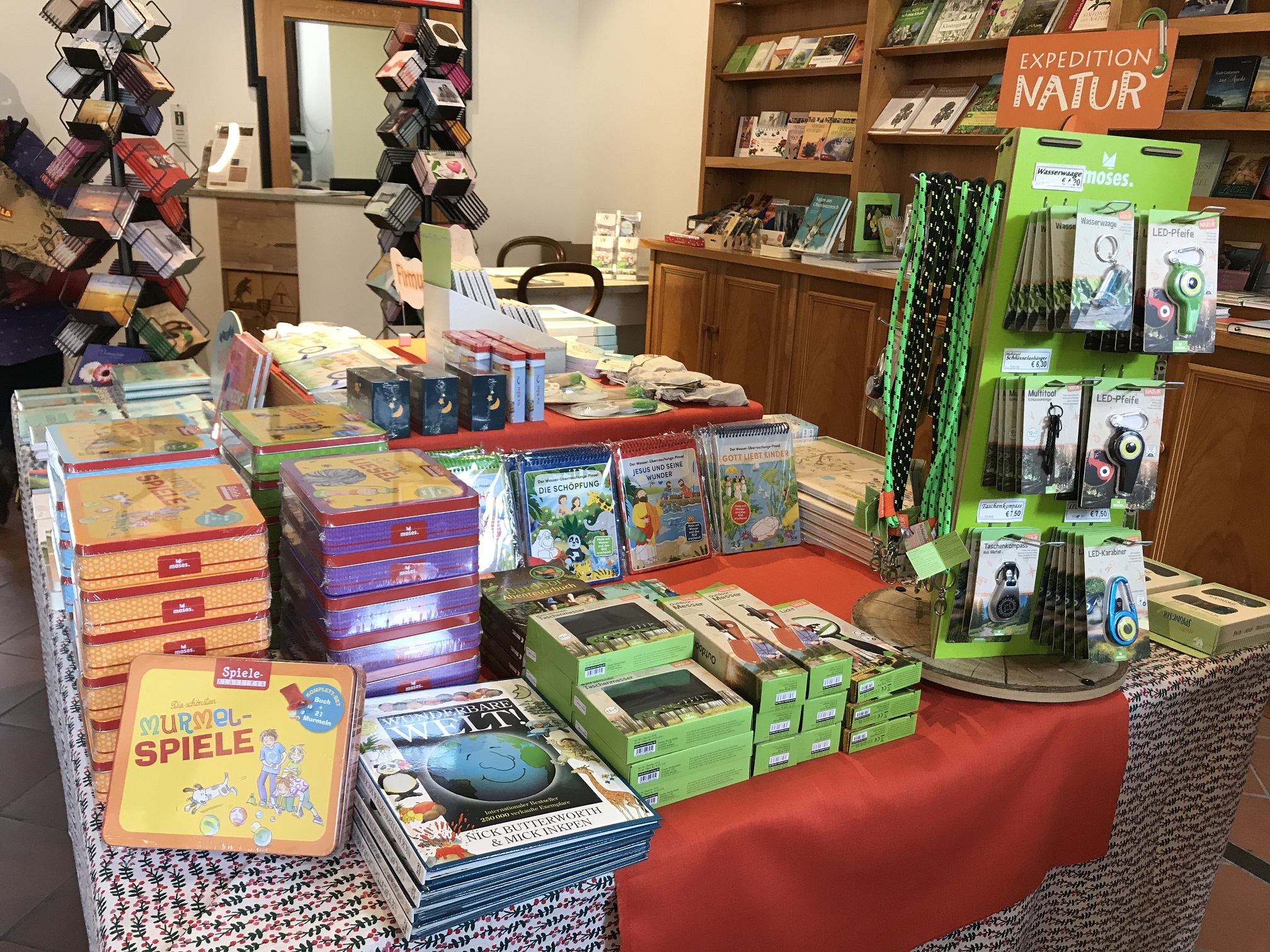 Ein Tisch im Klosterladen, gedeckt mit tollen Spielen, Karten, Büchern und mehr