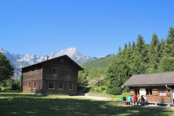 Agapitusheim am Almsee, Holzhütte umgeben von Wald und Bergen