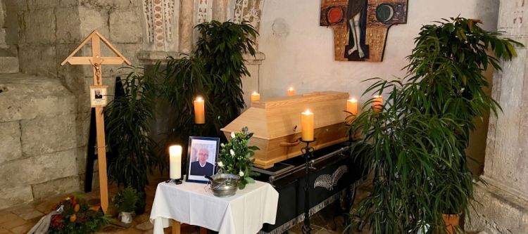 sarg aufgebahrt mit brennenden Kerzen