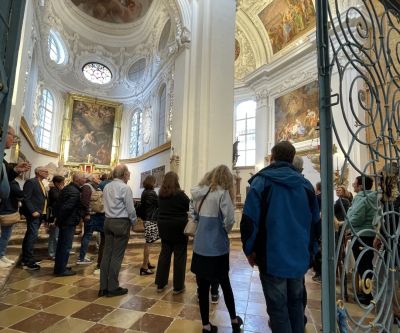 rotes Baugerüst im Inneren einer Kirche, nach oben hin Blick auf Stuck und Fresken