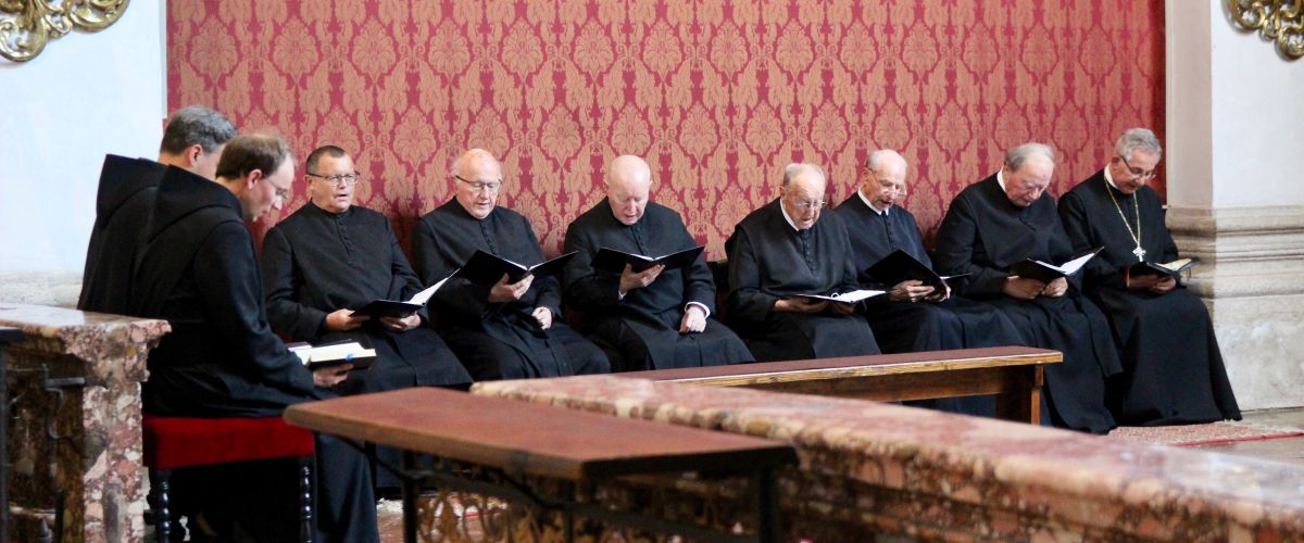 Mehrere Mönche sitzen gemeinsam beim Stundengebet