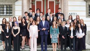 Maturantinnen und Maturanten festlich gekleidet vor einem Portal