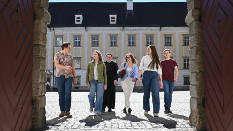 Gruppe von sechs jungen Leuten in einem Torbogen