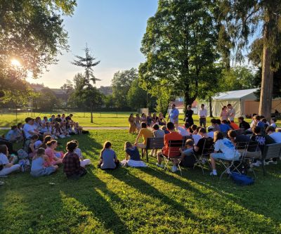 Abschlussfoto aller Beteiligten des Jugendtreffens im Stift Kremsmünster auf der Bühne im Zelt mit Jesus Bild und Text: "Jesus, ich vertraue auf dich"