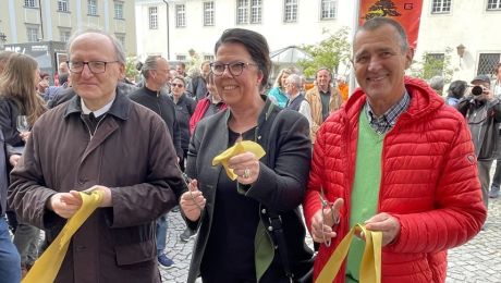 Drei Personen halten ein Band