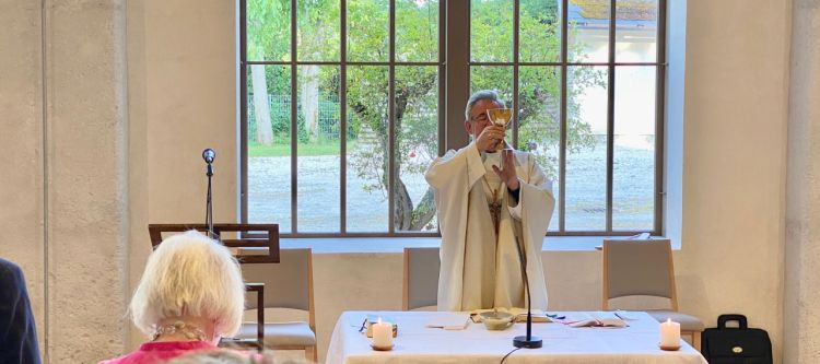 Priester mit Messkelch bei der Eucharistiefeier