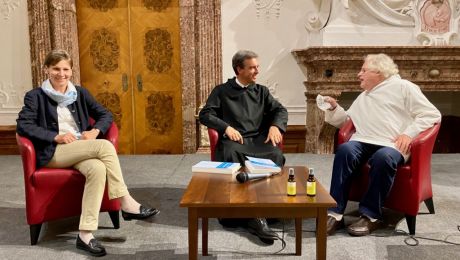 Drei Personen sitzend bei Interview auf Podium