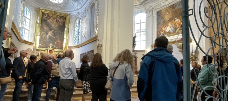 rotes Baugerüst im Inneren einer Kirche, nach oben hin Blick auf Stuck und Fresken