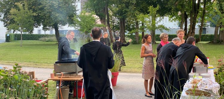 mehrere personen beim grillen im garten