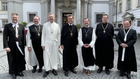 Eine Personengruppe von sieben Äbten mit Blick in die Kamera