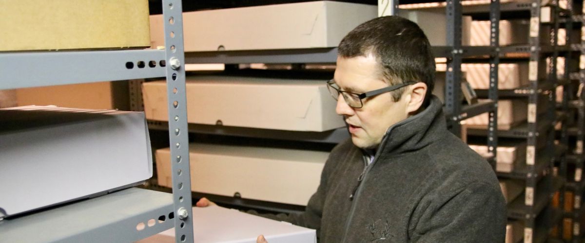 Mann sucht nach einem alten Schriftstück im Stiftsarchiv