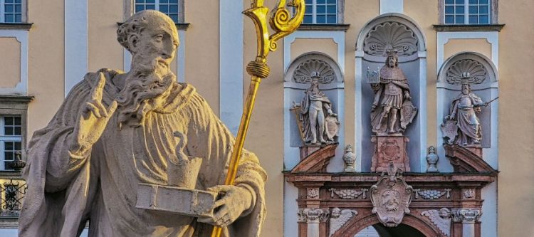 statue des heiligen benedikt, im hintergrund ein portal mit drei statuen