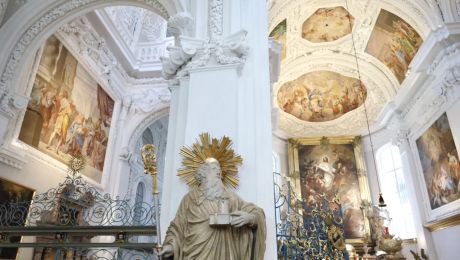 Altarraum mit weißem Stuck, Fresken, Altarbild und Statue des heiligen Benedikt