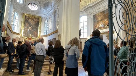 rotes Baugerüst im Inneren einer Kirche, nach oben hin Blick auf Stuck und Fresken