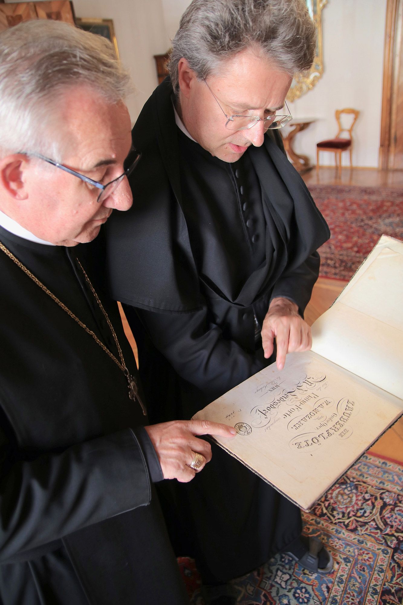 Abt Ambros und Pater Altman beim Blick in ein altes musikalisches Meisterwerk