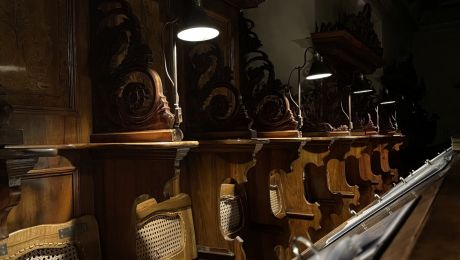 Lampen leuchten auf Sitze von dunklem Holzgestühl