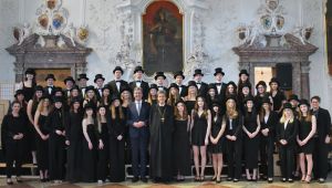 Gruppenfoto in einem Festsaal mit circa 50 jungen Personen festlich schwarz gekleidet mit Zylinder