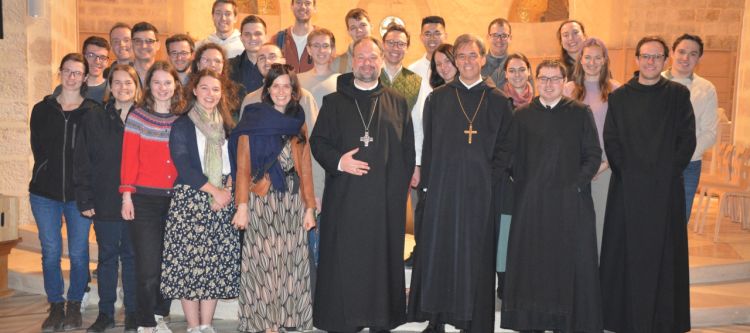 Gruppe von jungen Leuten mit zwei Äbten und zwei Mönchen in einer Kirche