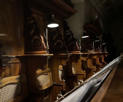 Lampen leuchten auf Sitze von dunklem Holzgestühl