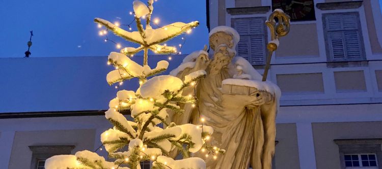 Statue des heiligen Benedikt mit Christbaum und Schnee