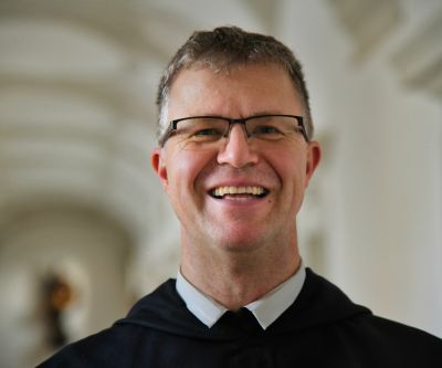 Porträt eines Mönches mit kurzem braunem Haar und Brille