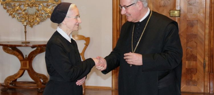 Zwei Personen geben sich die Hand zur Gratulation