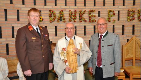 Drei Personen mit Holzstatue des heiligen Laurentius