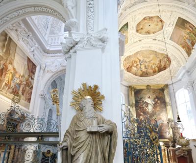 Altarraum mit weißem Stuck, Fresken, Altarbild und Statue des heiligen Benedikt