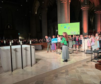 Gruppe von Schülerinnen und Schüler in großem Kirchenraum, links im Bild ein Altar, in der Mitte eine Sprecherin