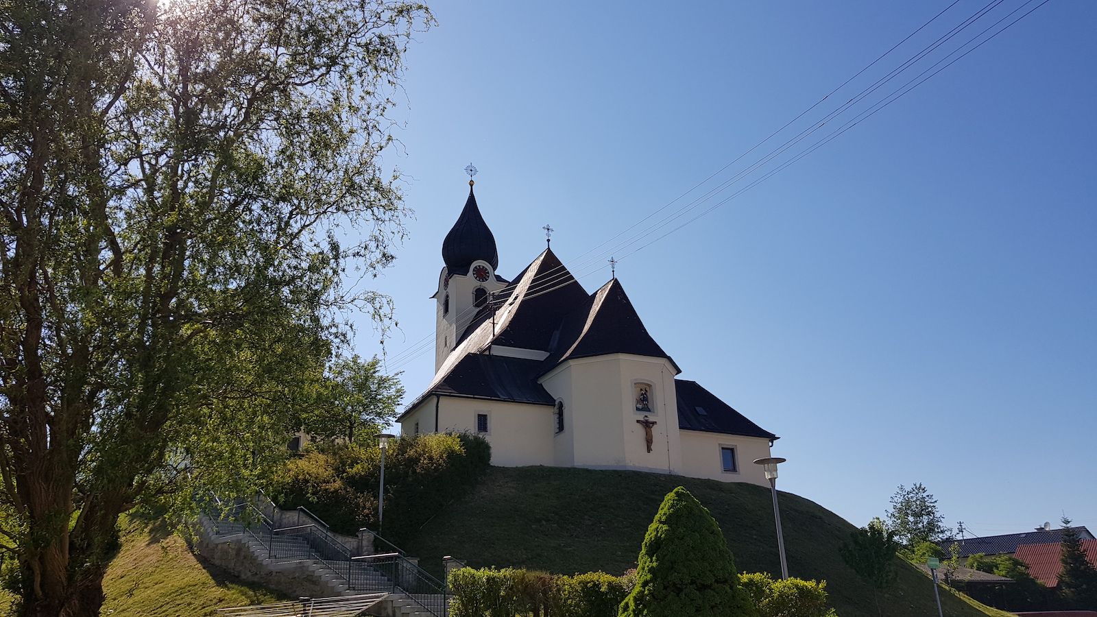 Aufgang zur Pfarrkirche Rohr mit Blick auf Jesuskreuz auf der Gebäude Rückseite