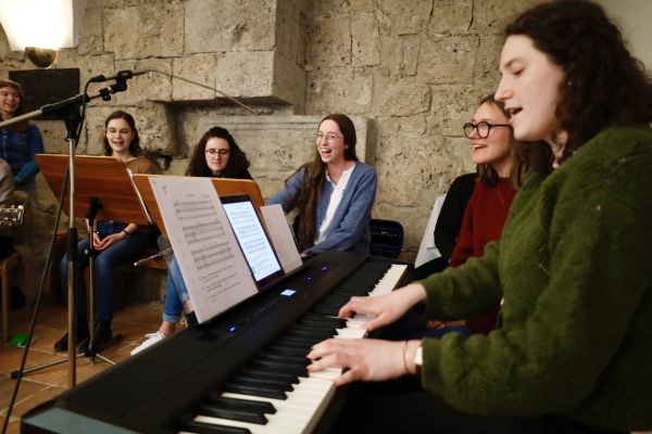 Gruppenfoto der Musikband beim Singen und Musizieren. Ein Keyboard ragt ins Bild.
