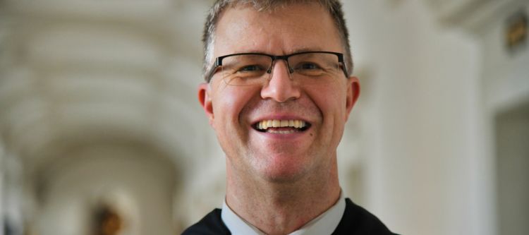 Porträt eines Mönches mit kurzem braunem Haar und Brille