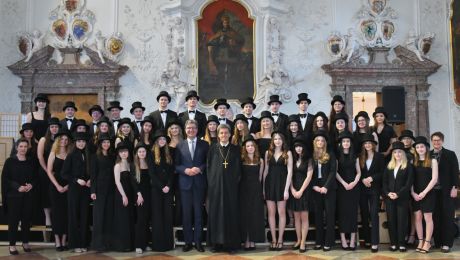 Gruppenfoto in einem Festsaal mit circa 50 jungen Personen festlich schwarz gekleidet mit Zylinder