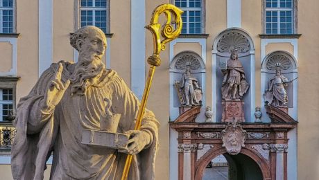 statue des heiligen benedikt, im hintergrund ein portal mit drei statuen
