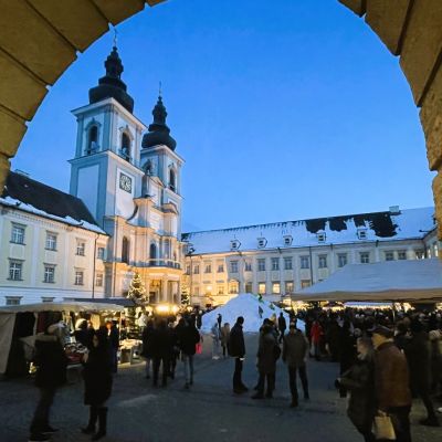 Blick in einer Winternacht über den Adventmarkt auf die Stiftskirche